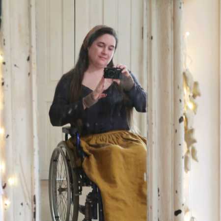 Lucy Catchpole - a white wheelchair user wearing a mustard coloured linen skirt.