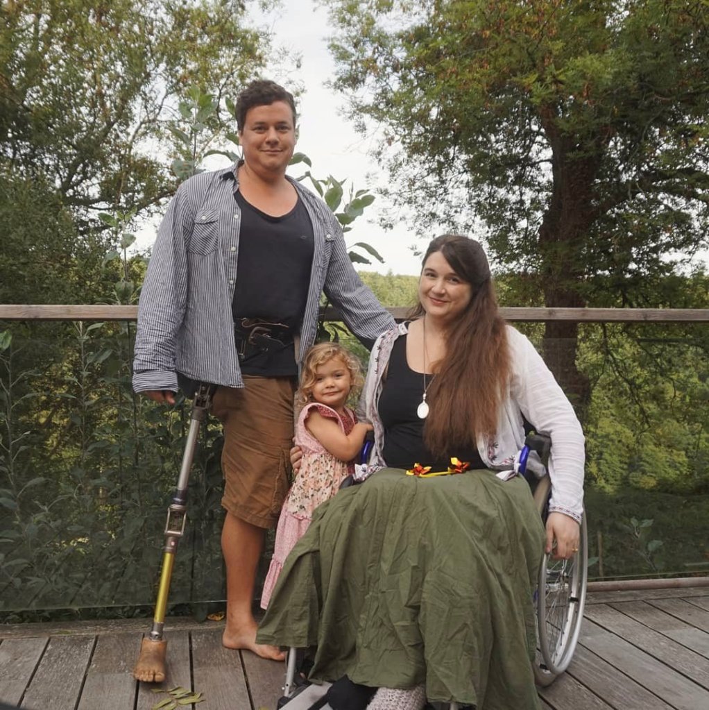 A photo showing Lucy is a wheelchair user in a manual chair, and James is an amputee.