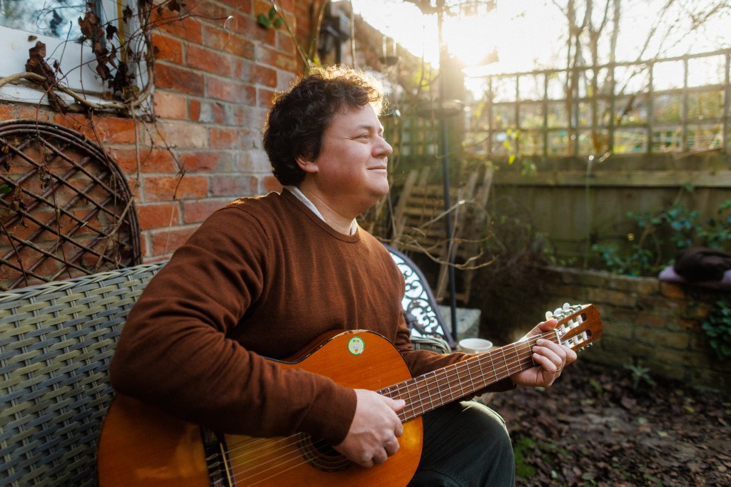 James Catchpole with his guitar in the garden - photo by Jon Attenborough