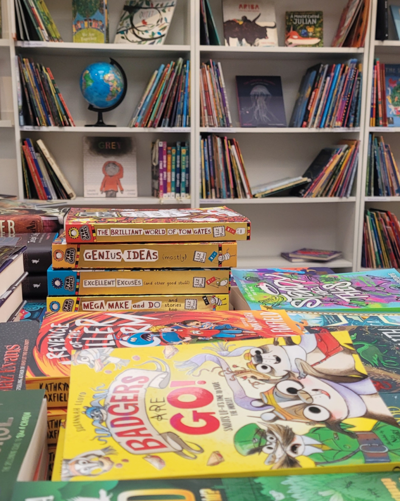 Badgers Are Go. A pile of copies of Badgers Are Go! in the bookshop table display - a middle grade novel by Susannah Lloyd, illustrated by Nici Gregory, with a yellow cover.