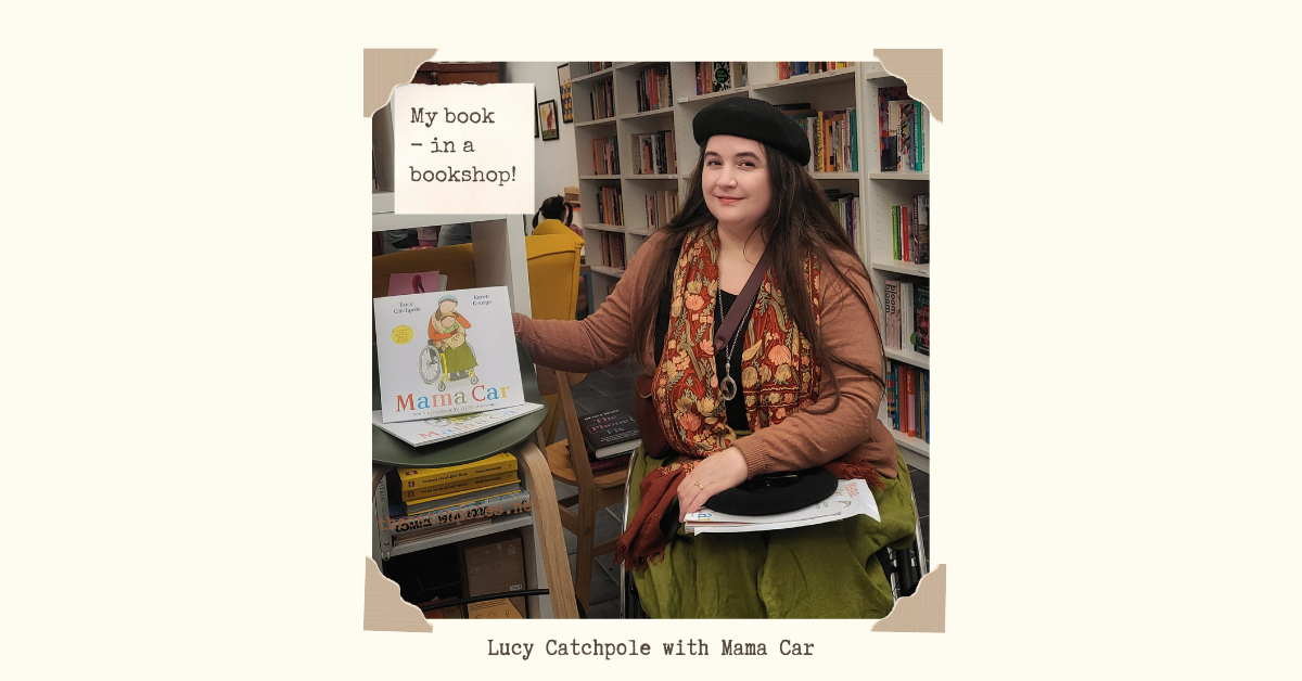 Lucy Catchpole with Mama Car in a bookshop.
I’m in Caper Oxford next to a display of my picture book Mama Car, sitting in my wheelchair, smiling at the camera. I’m wearing my green linen skirt, burnt orange cardigan, embroidered scarf & black beret. Mama Car cover art: a white background, a wheelchair-using mother on the front with a child on her lap, who looks slightly like me - illustrated by Karen George.