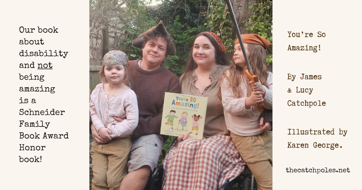 A photo of our family, celebrating "You're So Amazing!" receiving a Schneider Family Book Award Honor from the ALA. Text reads: “Our book about disability and NOT being amazing is a Schneider Family Book Award Honor book! We’re in our garden, trees and greenery behind. James and Lucy - a white disabled couple - and their two young daughters wear clothes that vaguely suggest a pirate theme, with hats and bandanas. We’re all sitting, with Lucy in her wheelchair - holding a book our picture book "You're SO Amazing!". Viola - age 6 - has an open-mouthed expression of great joy / surprise - who can tell? Book cover: “You're So Amazing” - the US hardback, a children's picture book with a cream background. On the illustrated cover are three children between 4 and 6yo - an East Asian boy, a white one-legged boy with yellow crutches, and a Black girl. They have a football and look happy. 