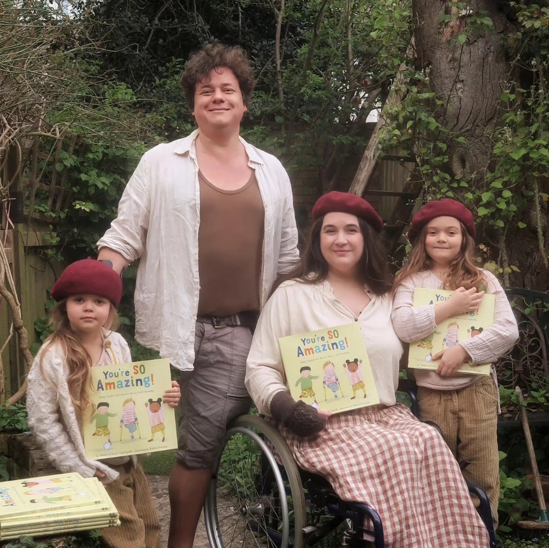 Lucy and James Catchpole with their picture book You're So Amazing - and their two daughters. Lucy is a wheelchair user, James has one leg.